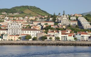 A scenic view of Horta, the charming capital of Faial Island, with its colorful buildings and lush green hills.