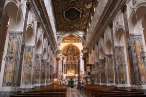 Interior of a historic church in Italy, featuring intricate architectural details, marble columns, and ornate decorations.