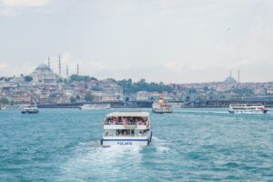 A scenic view of the Bosphorus in Istanbul, Turkey, with the Suleymaniye Mosque in the background and several boats, including one named Polaris, traversing the water.